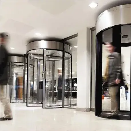 Revolving entrance-control doors managing visitor access in a building lobby.
